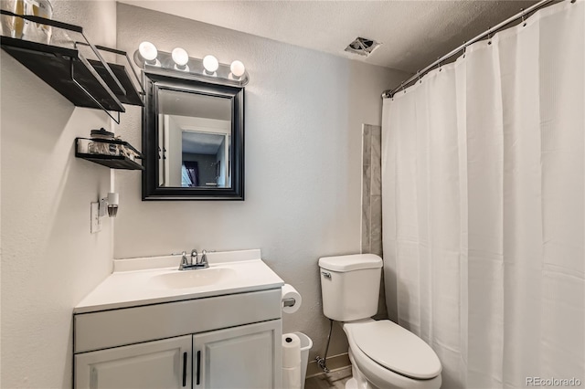 bathroom featuring vanity, a textured ceiling, and toilet