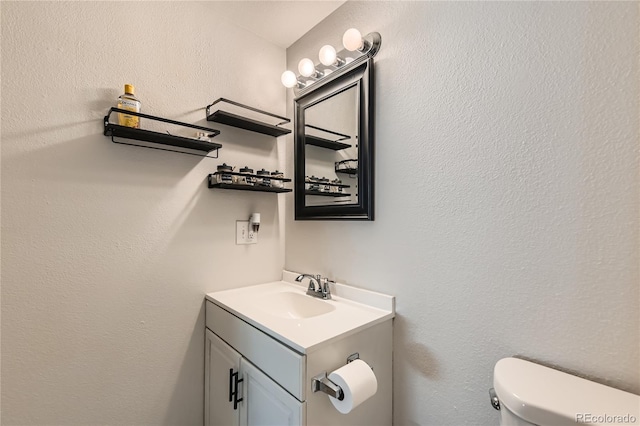 bathroom featuring vanity and toilet