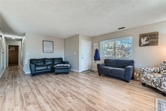 living room with light hardwood / wood-style floors and a textured ceiling