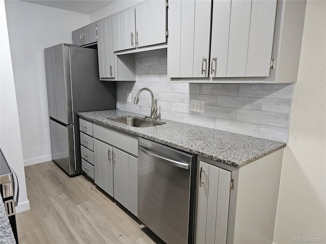 16259 W 10th Ave Unit K-3, Golden, CO 80401 - kitchen with stainless steel appliances, light wood finished floors, backsplash, and light stone countertops