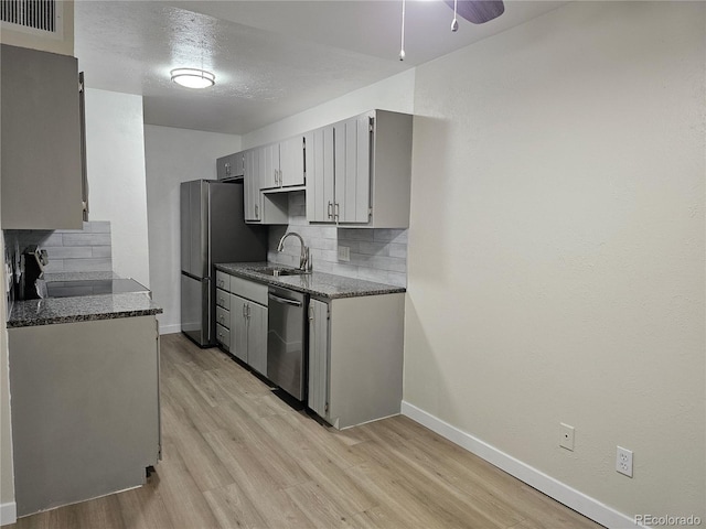 16259 W 10th Ave Unit K-3, Golden, CO 80401 - kitchen featuring appliances with stainless steel finishes, backsplash, light wood-style flooring, a ceiling fan, and a textured ceiling