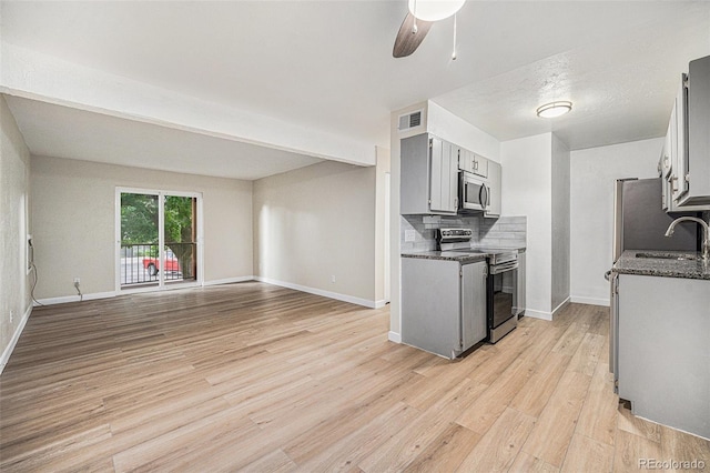 16259 W 10th Ave Unit K-3, Golden, CO 80401 - kitchen featuring appliances with stainless steel finishes, light wood finished floors, a ceiling fan, tasteful backsplash, and open floor plan