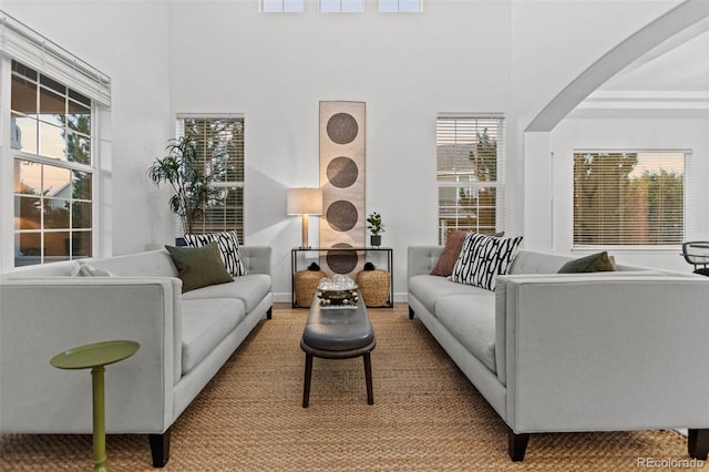 carpeted living room with a towering ceiling