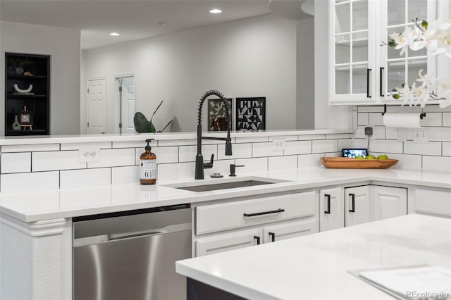 kitchen with dishwasher, white cabinetry, sink, and tasteful backsplash