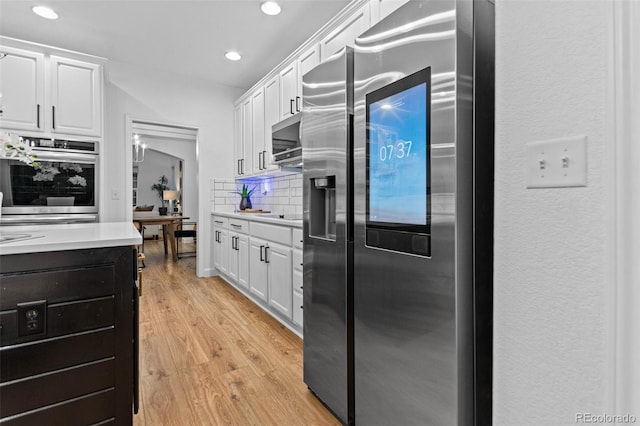 kitchen featuring white cabinetry, stainless steel appliances, and tasteful backsplash