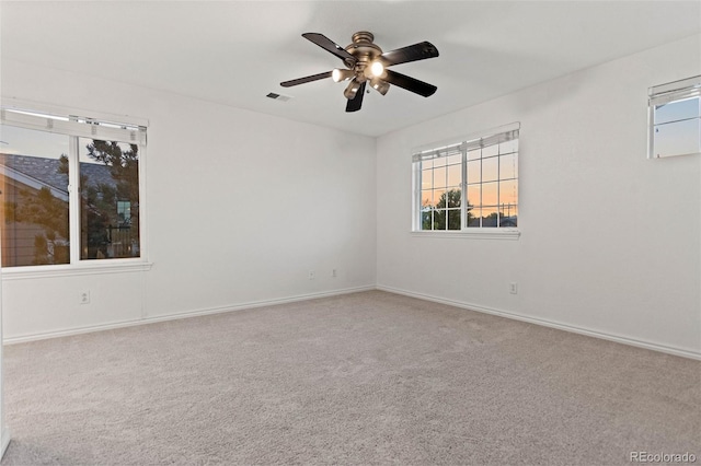 carpeted spare room with ceiling fan