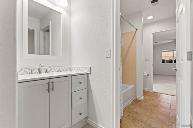 bathroom with tile patterned floors, vanity, and tiled shower / bath