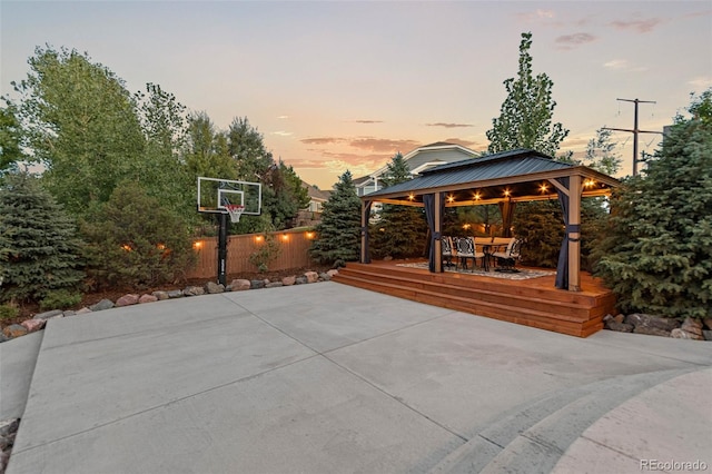 patio terrace at dusk featuring a gazebo and a wooden deck