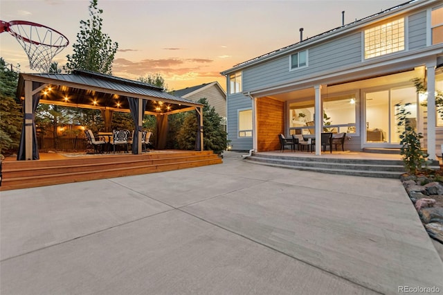 back house at dusk featuring a patio