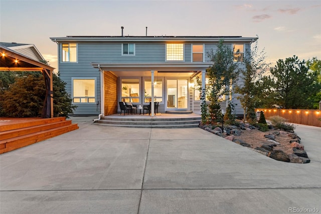 back house at dusk with a patio