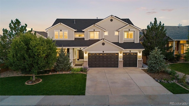 craftsman inspired home with a lawn and a garage