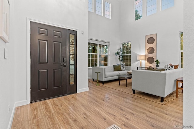 foyer featuring light hardwood / wood-style floors and a towering ceiling