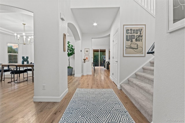 foyer entrance featuring a notable chandelier, plenty of natural light, and light hardwood / wood-style flooring