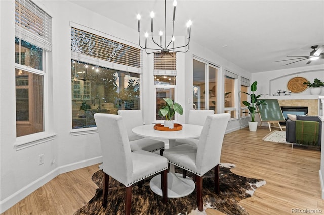 dining space featuring ceiling fan with notable chandelier and hardwood / wood-style flooring