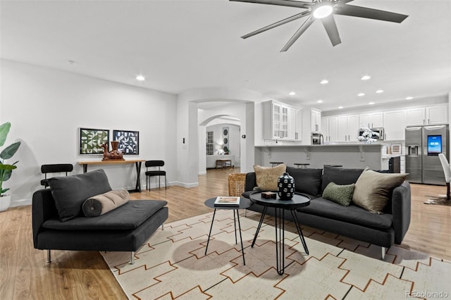 living room featuring ceiling fan and light hardwood / wood-style flooring