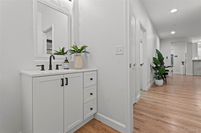 hallway with light hardwood / wood-style flooring and sink