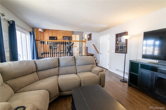 living room featuring dark hardwood / wood-style flooring and a textured ceiling