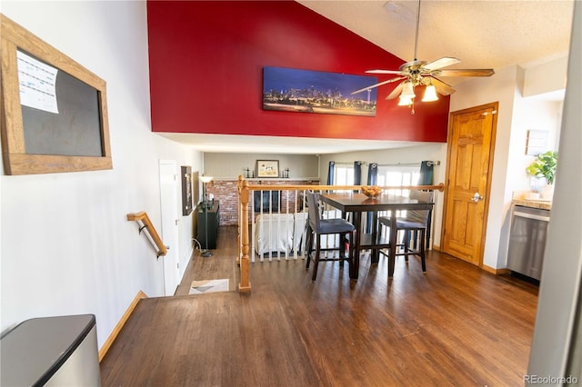 dining room with ceiling fan, dark hardwood / wood-style flooring, high vaulted ceiling, and a textured ceiling