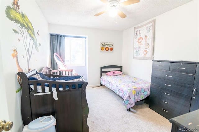 carpeted bedroom featuring a textured ceiling and ceiling fan