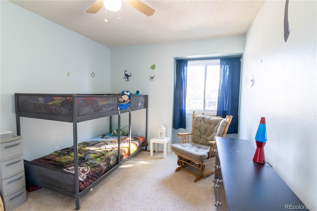 carpeted bedroom featuring a textured ceiling and ceiling fan