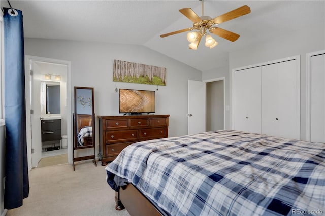 bedroom featuring lofted ceiling, light carpet, ceiling fan, and ensuite bath