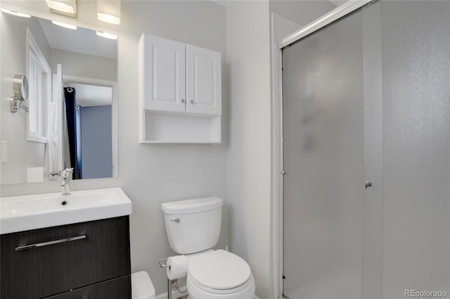 bathroom featuring a stall shower, vanity, and toilet