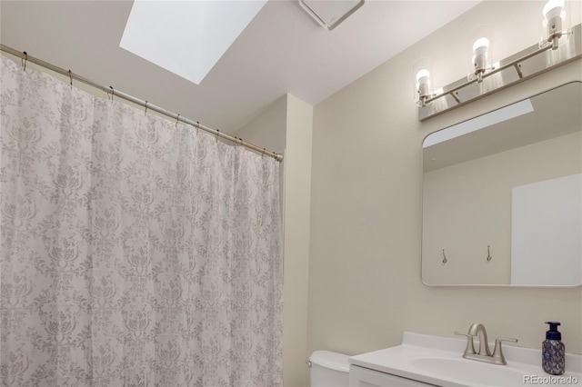 full bathroom with a skylight, curtained shower, vanity, and toilet