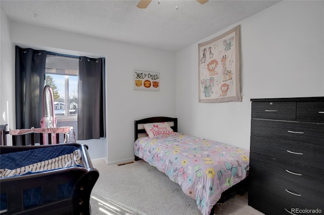 bedroom with a ceiling fan, carpet flooring, a textured ceiling, and baseboards