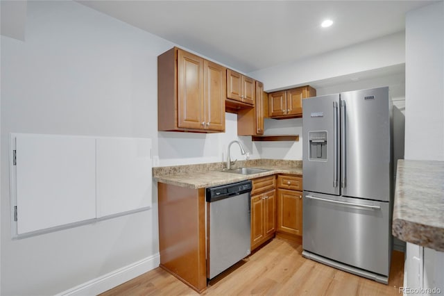 kitchen with recessed lighting, a sink, light wood-style floors, light countertops, and appliances with stainless steel finishes