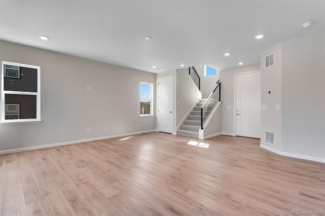 unfurnished living room featuring light wood-type flooring, recessed lighting, stairway, and visible vents
