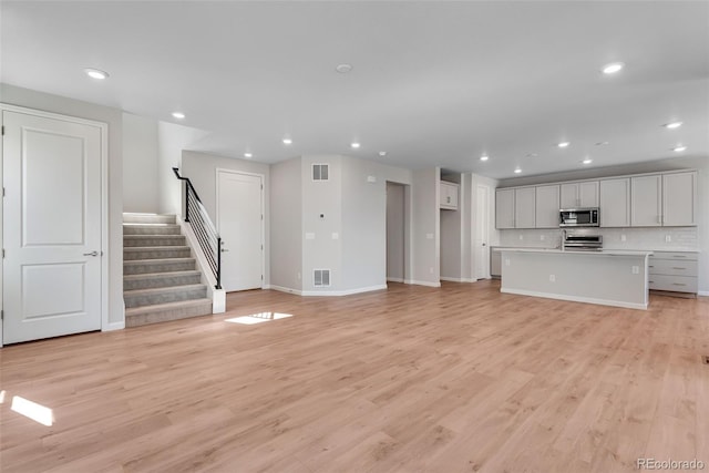 unfurnished living room with visible vents and recessed lighting