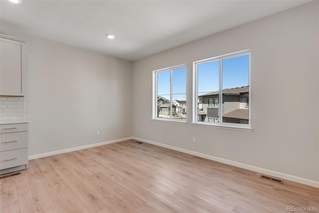 unfurnished room featuring recessed lighting, baseboards, visible vents, and light wood-style floors