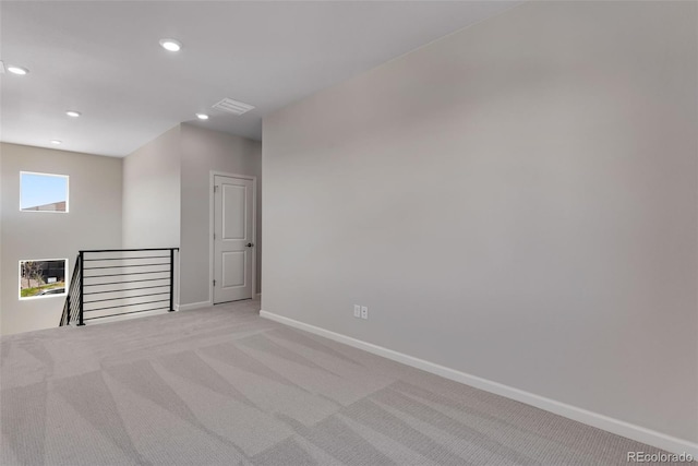 empty room featuring light colored carpet, baseboards, visible vents, and recessed lighting