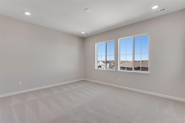 unfurnished room with light colored carpet, visible vents, baseboards, and recessed lighting
