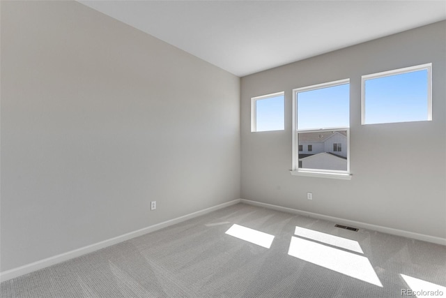 unfurnished room with light carpet, baseboards, and visible vents