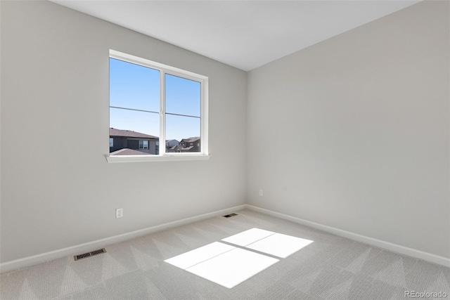 carpeted empty room with visible vents and baseboards