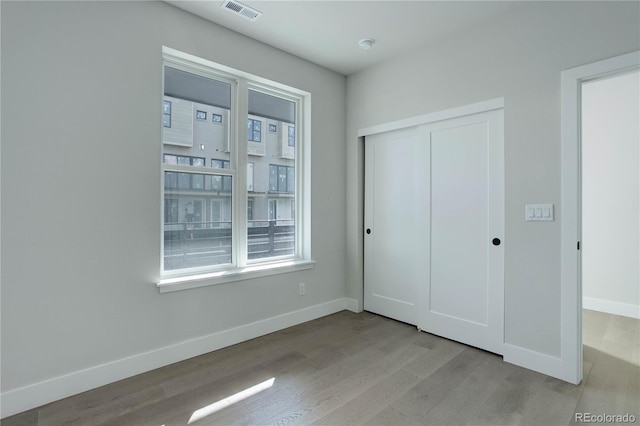 unfurnished bedroom featuring light hardwood / wood-style floors and a closet