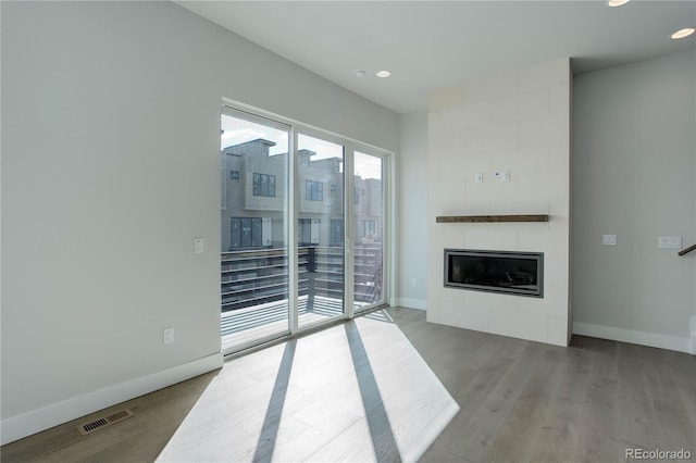 living room with a fireplace and light wood-type flooring