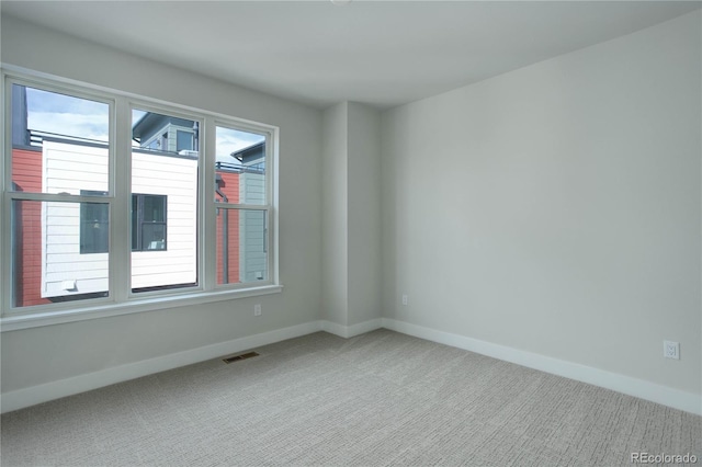 unfurnished room with carpet floors and plenty of natural light