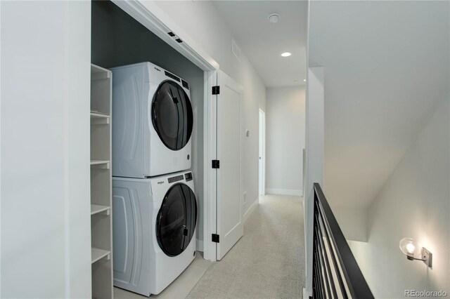 washroom featuring light carpet and stacked washer / drying machine