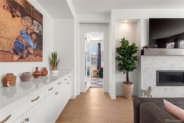 hallway featuring light wood-style flooring and baseboards