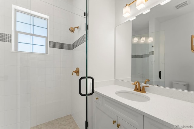 full bath with toilet, a stall shower, visible vents, and vanity