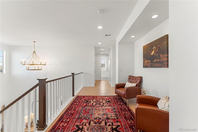 hallway featuring recessed lighting, visible vents, a chandelier, light wood-type flooring, and baseboards