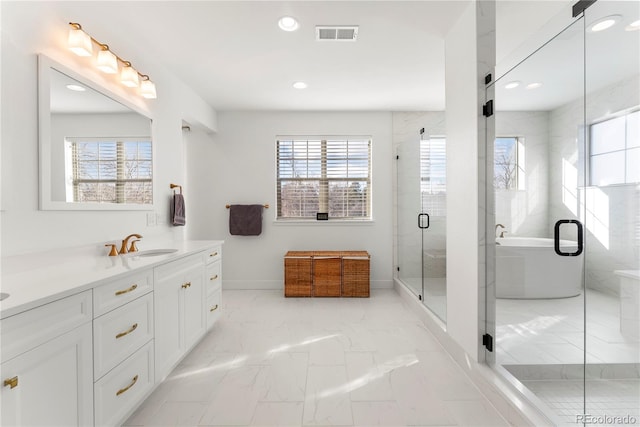 bathroom with a healthy amount of sunlight, marble finish floor, a stall shower, and vanity