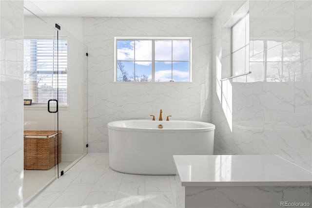 bathroom featuring a freestanding bath, marble finish floor, and a stall shower