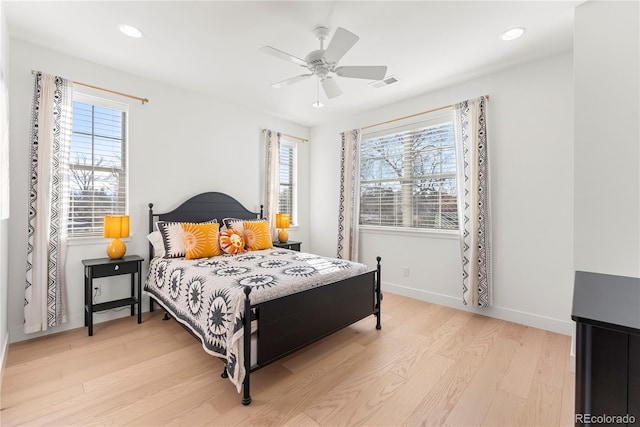 bedroom featuring light wood-type flooring, baseboards, multiple windows, and visible vents