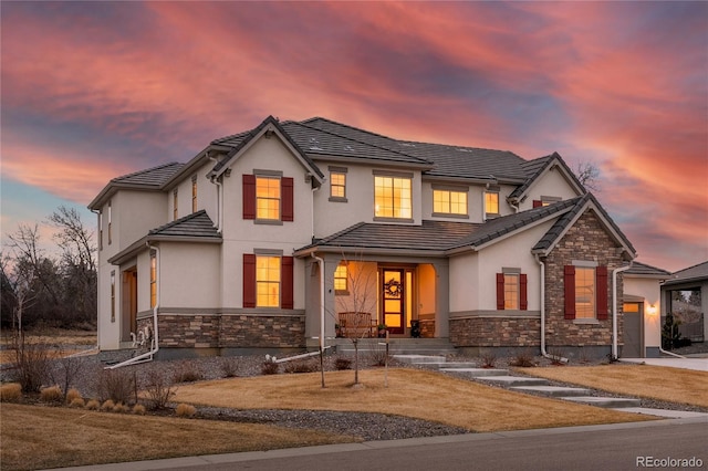 15 Latigo Pl, Littleton, CO 80123 - view of front of home featuring covered porch, a garage, stucco siding, a tile roof, and stone siding