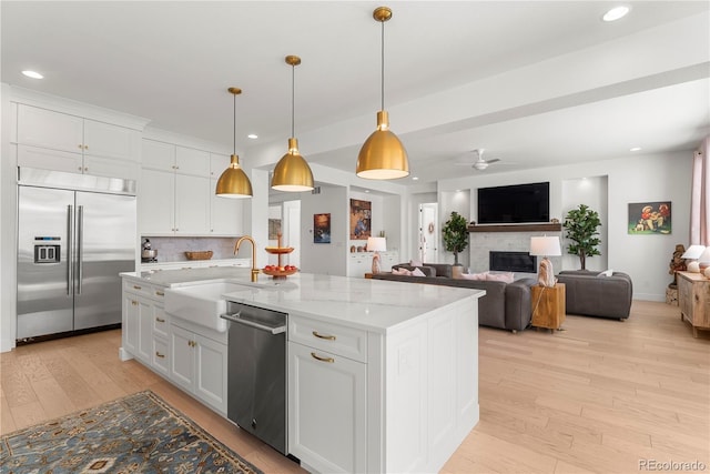 15 Latigo Pl, Littleton, CO 80123 - kitchen featuring appliances with stainless steel finishes, a sink, light wood-style flooring, recessed lighting, and white cabinetry