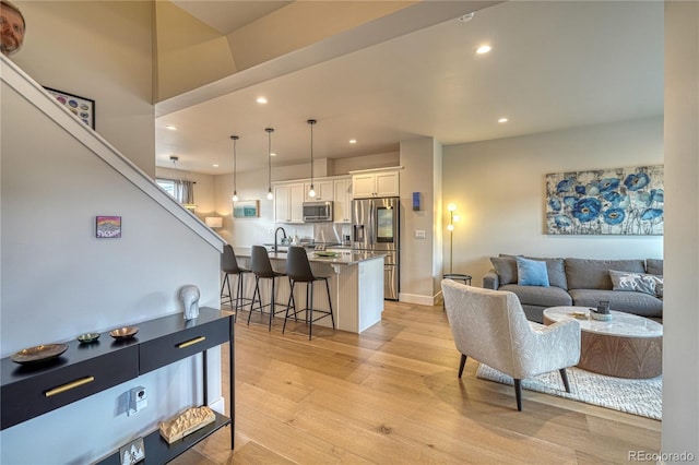 living room featuring light wood-type flooring and sink