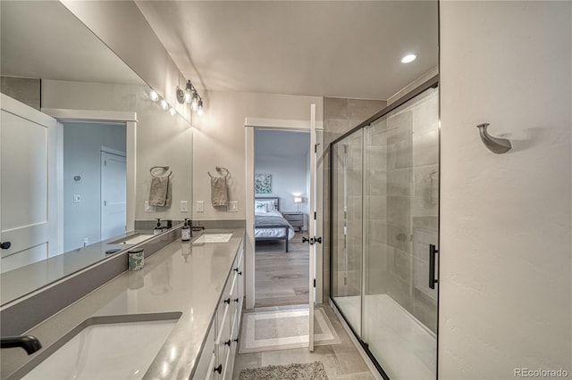 bathroom featuring a shower with shower door, hardwood / wood-style flooring, and vanity